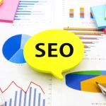 A table covered with pages of graphs and a speech bubble that say "SEO" laid on top of them.