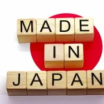 "Made in Japan" is spelled out with wooden blocks laid on top of the Japanese flag.