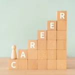 Building blocks stacked from shortest to tallest spelling out "career" with a small human figure at the bottom.